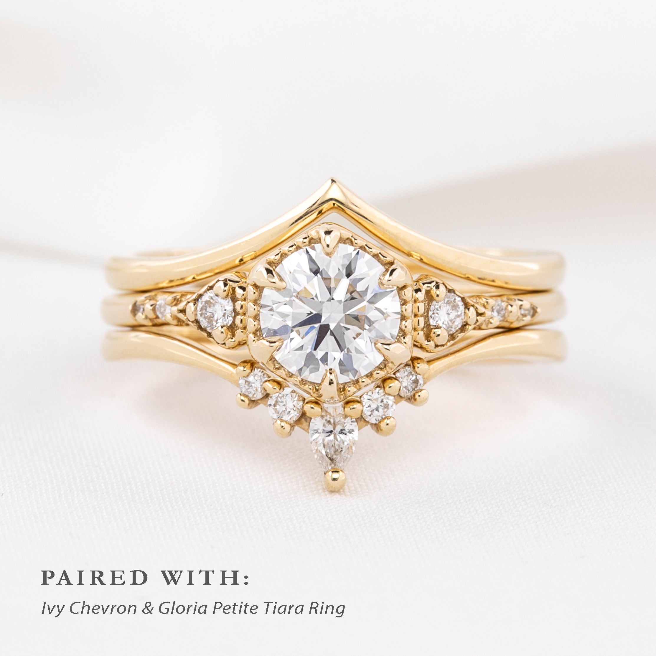 Close-up of Ivy Ring in ethically sourced solid gold with intricate diamond detailing on a soft white fabric background