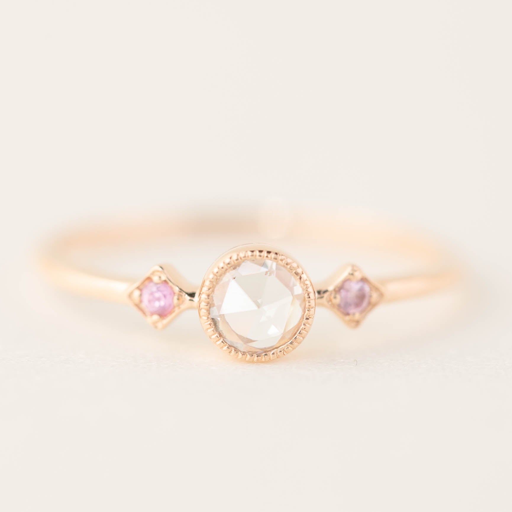 Rose gold Moon & Star ring with a rose-cut diamond center and two accent pink gemstones in milgrain bezel setting