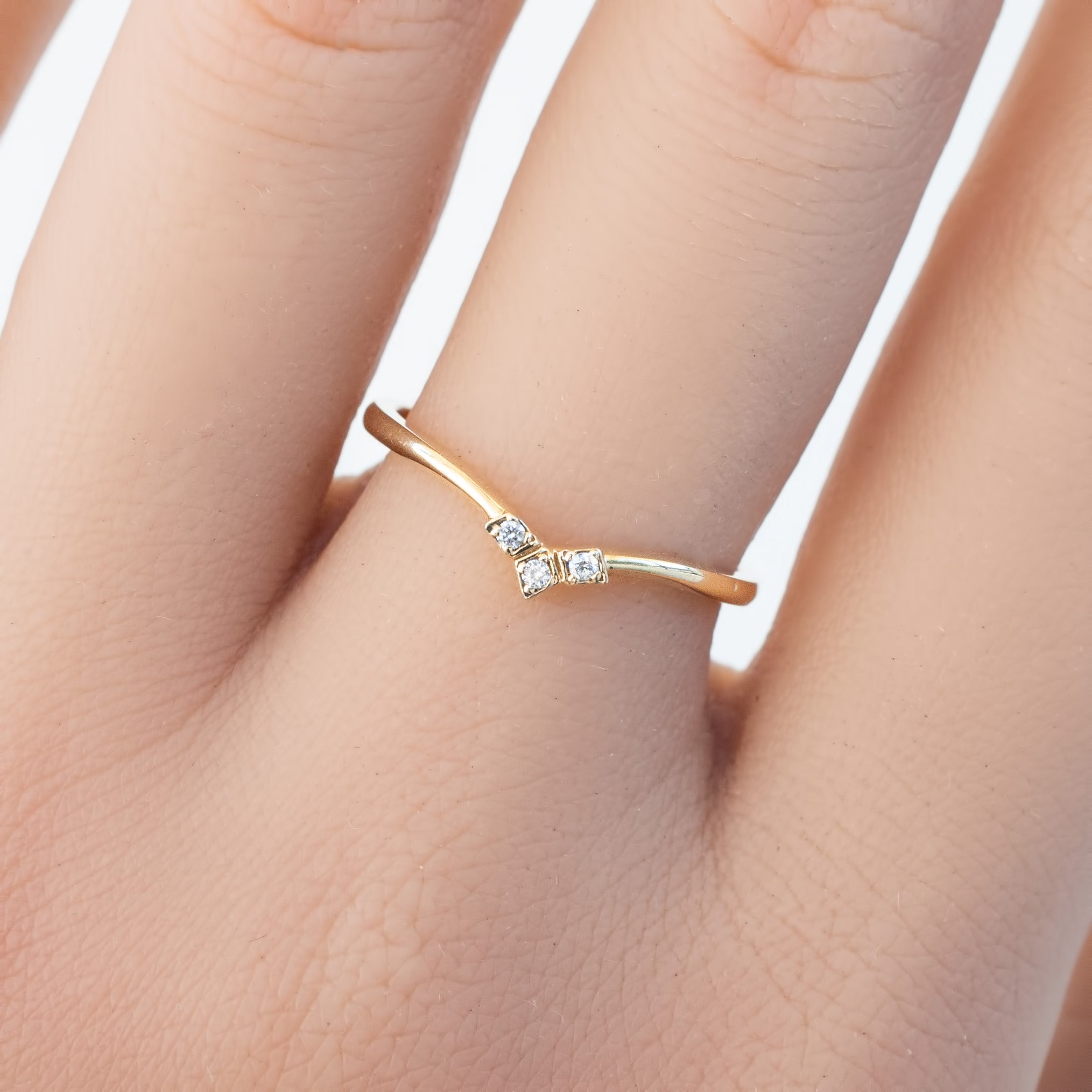 Solid gold triple star accent ring with natural white diamonds worn on a finger, packaged in recyclable kraft box