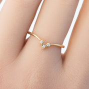 Delicate solid gold star accent ring with natural white diamonds on a slender band worn on finger