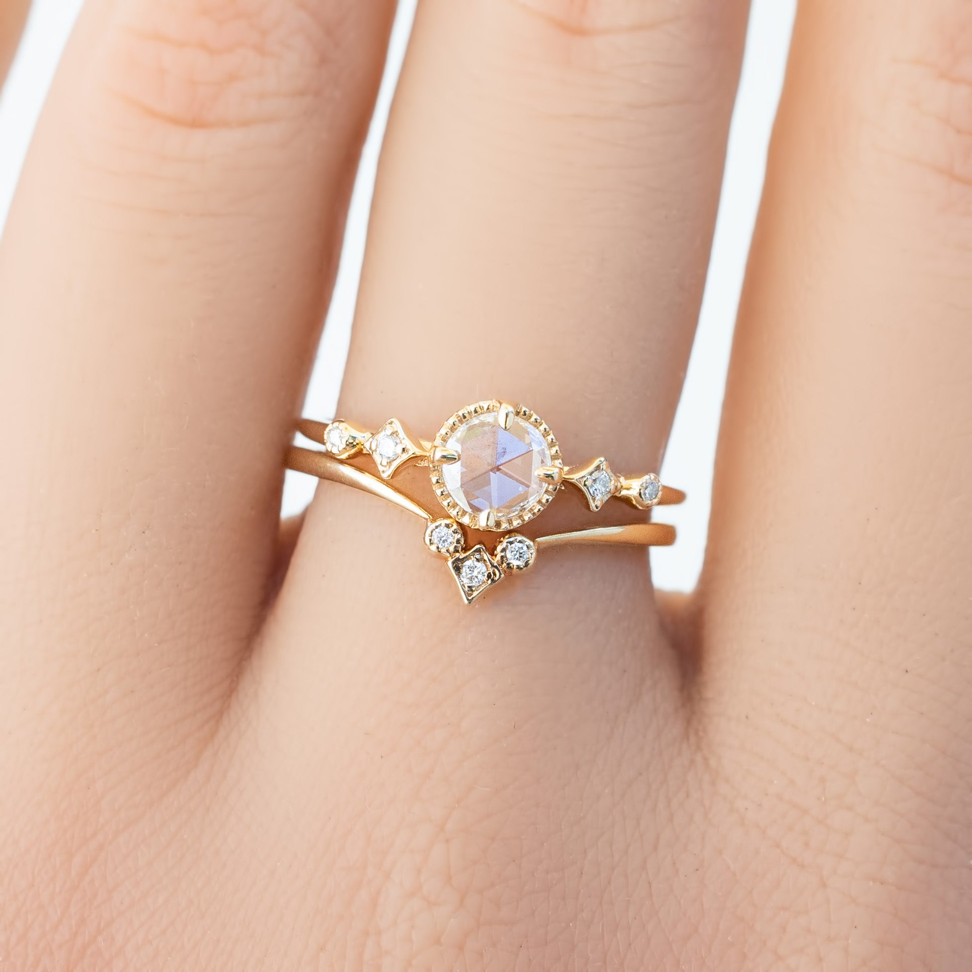 Close-up of a hand wearing a star accent ring with natural white diamonds set in ethically sourced solid gold band