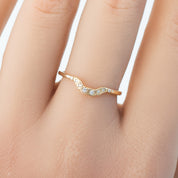 Isabel's curved solid gold ring with natural white diamonds on finger, delicate U-shaped band design