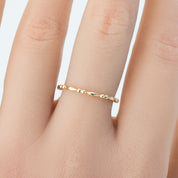Delicate 1.5mm solid gold Adina full eternity bead ring on finger in recyclable kraft box packaging