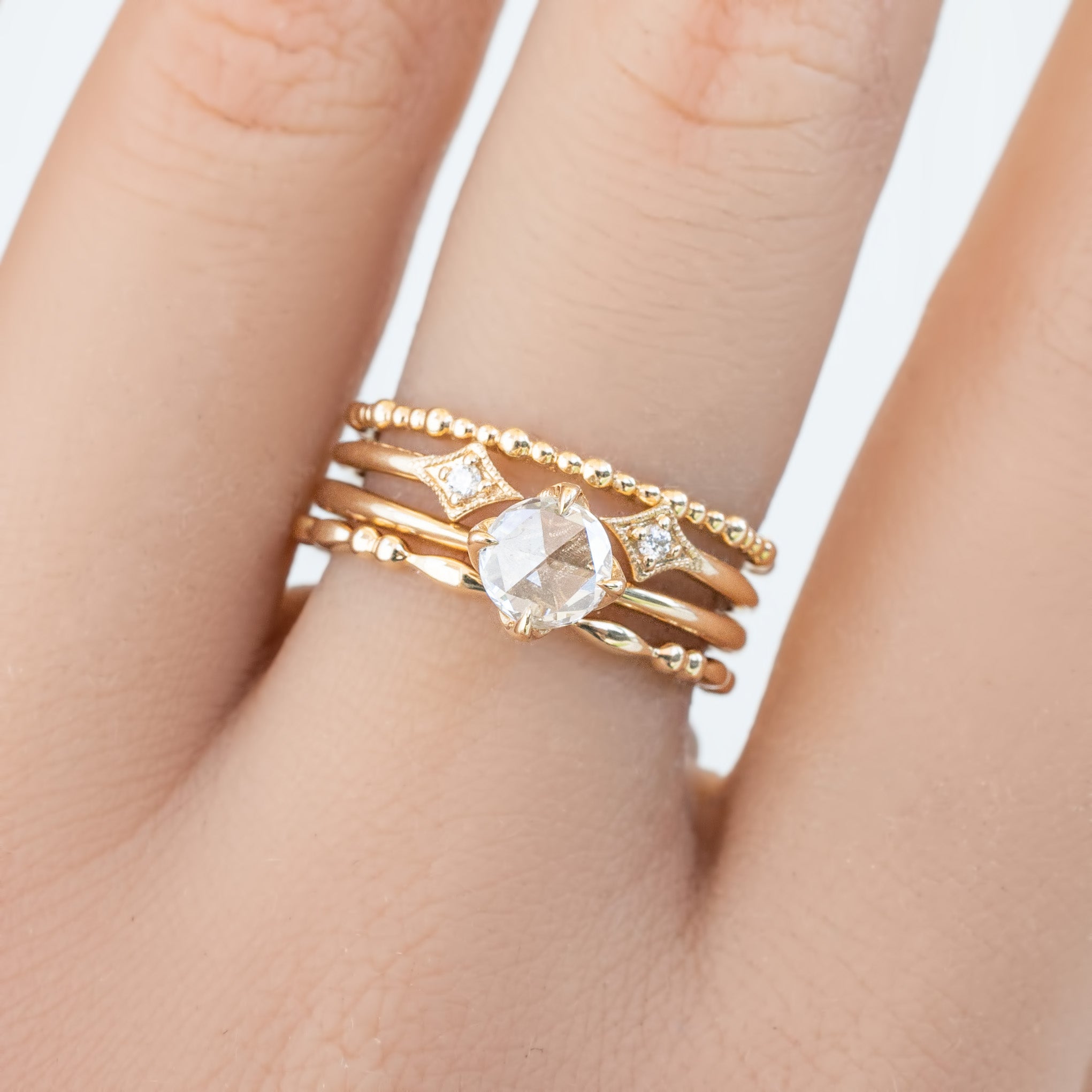 Close-up of a hand wearing the Adina Ring, a 1.5mm ethically sourced solid gold full eternity bead ring with diamonds.