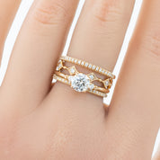 Hand wearing three gold rings, including a Meteor Diamond Band with natural white diamonds and solid gold band.