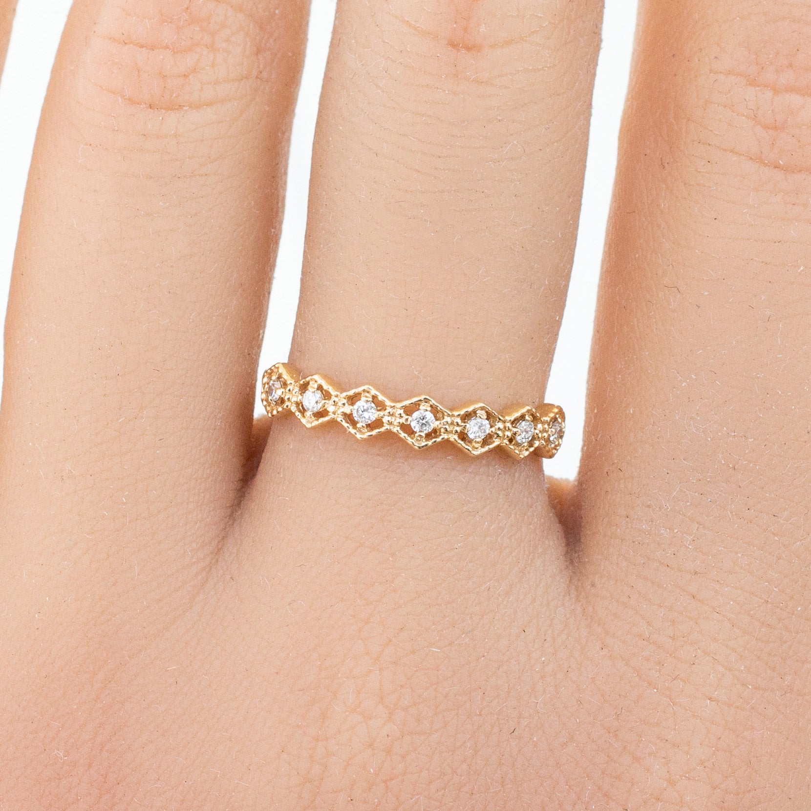 Milgrain hexagon ring with natural white diamonds set in ethically sourced solid gold on a finger