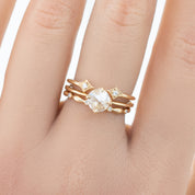 Close-up of a hand wearing a gold Aria Eternity Ring with natural white diamonds in full-eternity style