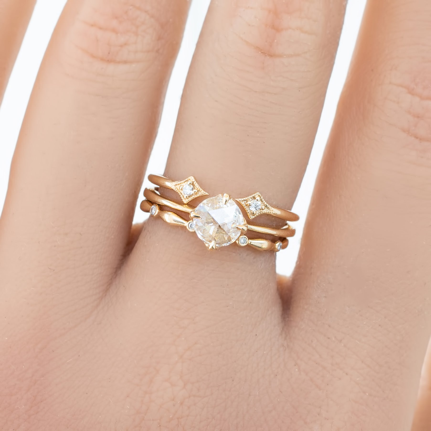 Close-up of a hand wearing a gold Aria Eternity Ring with natural white diamonds in full-eternity style