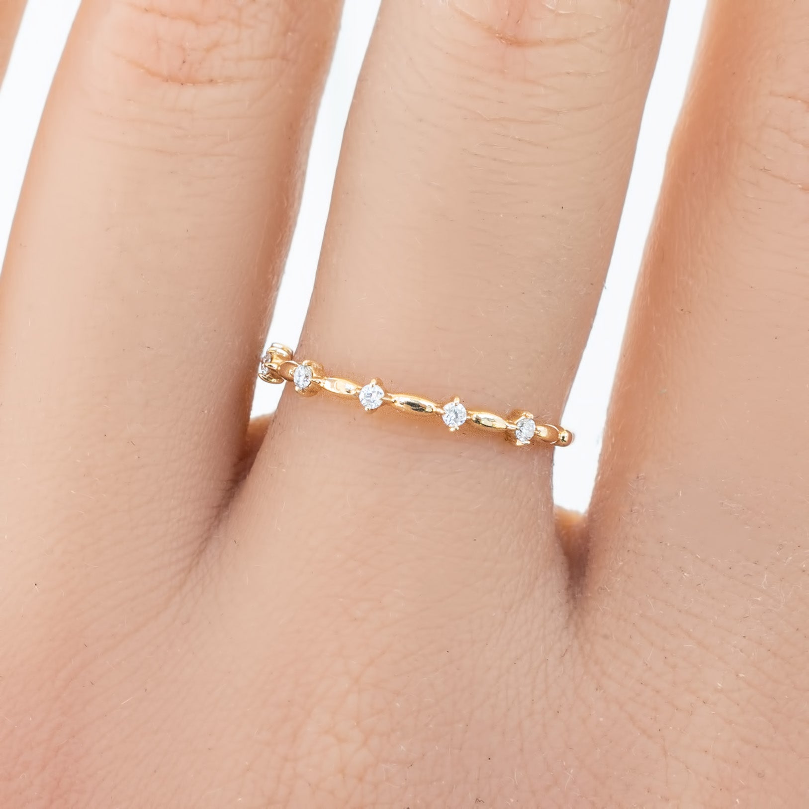 Delicate Distant Star Ring with natural white diamonds set in ethically sourced solid gold on a finger.