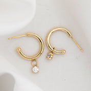 Gold hoop earring with measurements of appx 13.5mm diameter on a white background