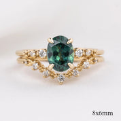 Oval green gemstone ring with white diamonds on V-shaped solid gold band in recyclable kraft box