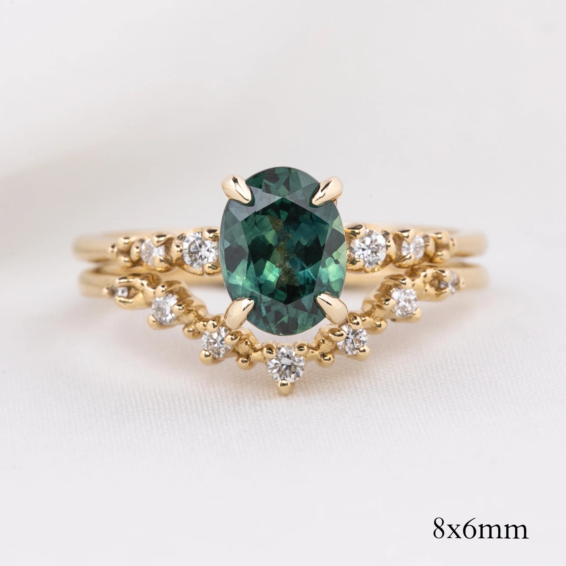 Oval green gemstone ring with white diamonds on V-shaped solid gold band in recyclable kraft box