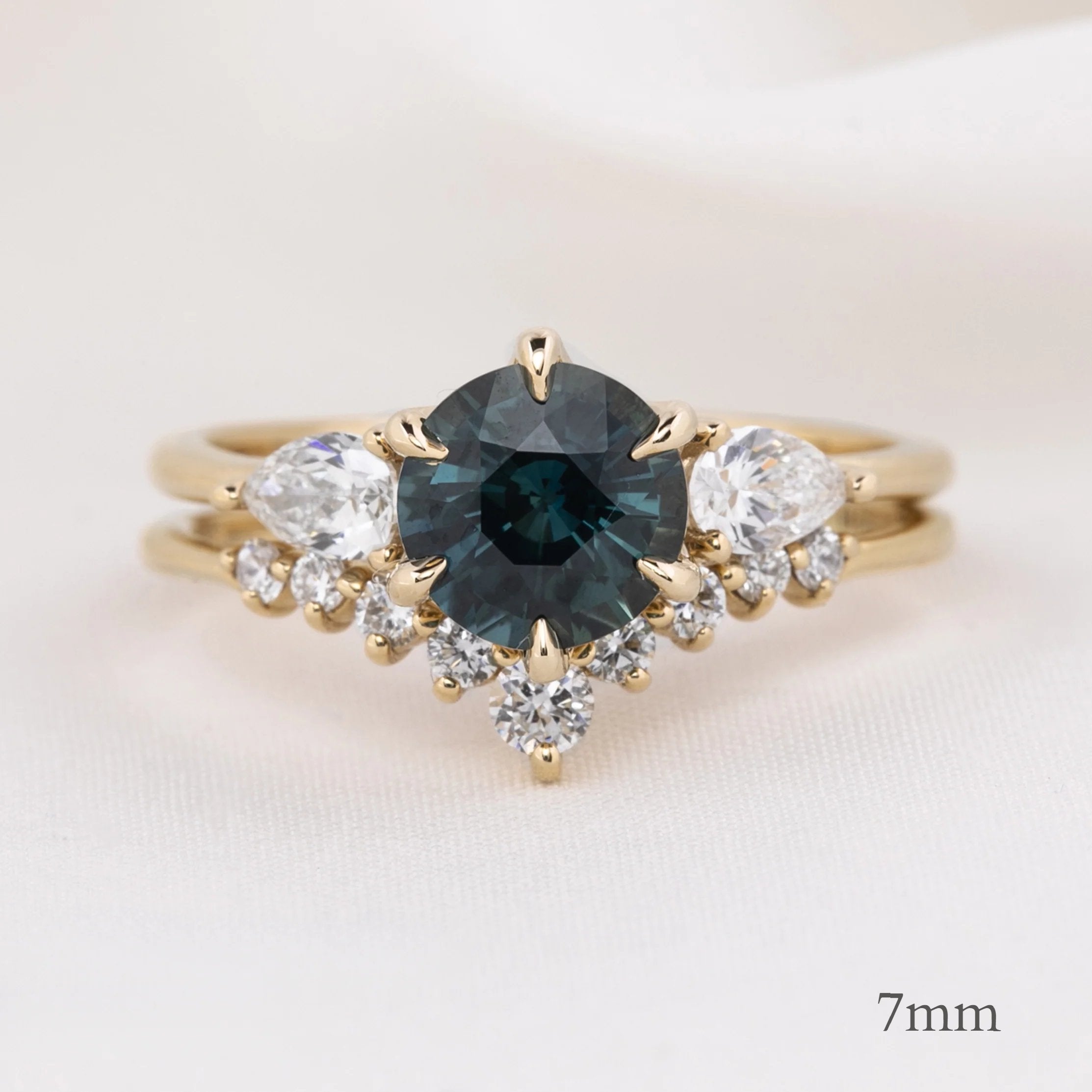 Lily's Tiara Ring featuring a 7mm deep blue center gemstone with ethically sourced gold and white diamonds