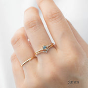 Hand wearing triple star accent ring with natural white diamonds on gold band against white background