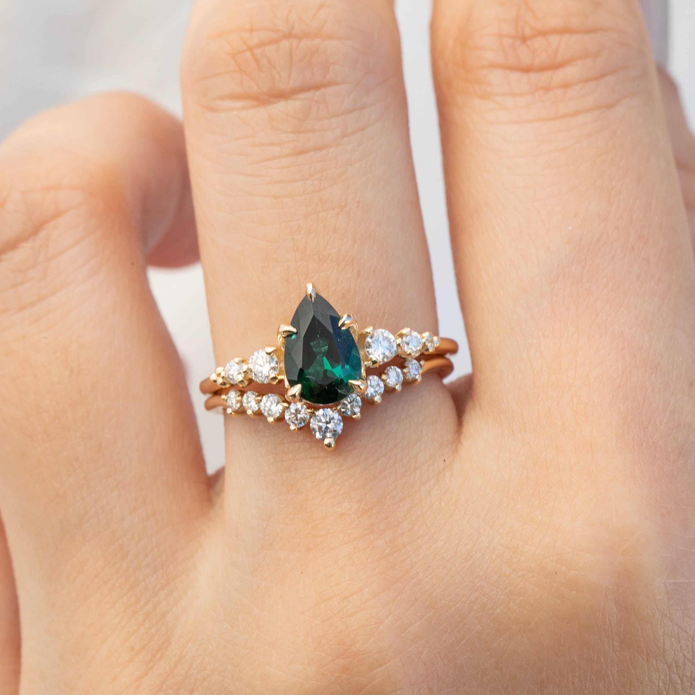 Lily's Tiara Ring featuring a pear-shaped green gemstone with sparkling diamonds in ethically sourced gold band