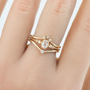 Hand wearing a solid gold star accent ring with natural white diamonds in recyclable kraft ivory box background