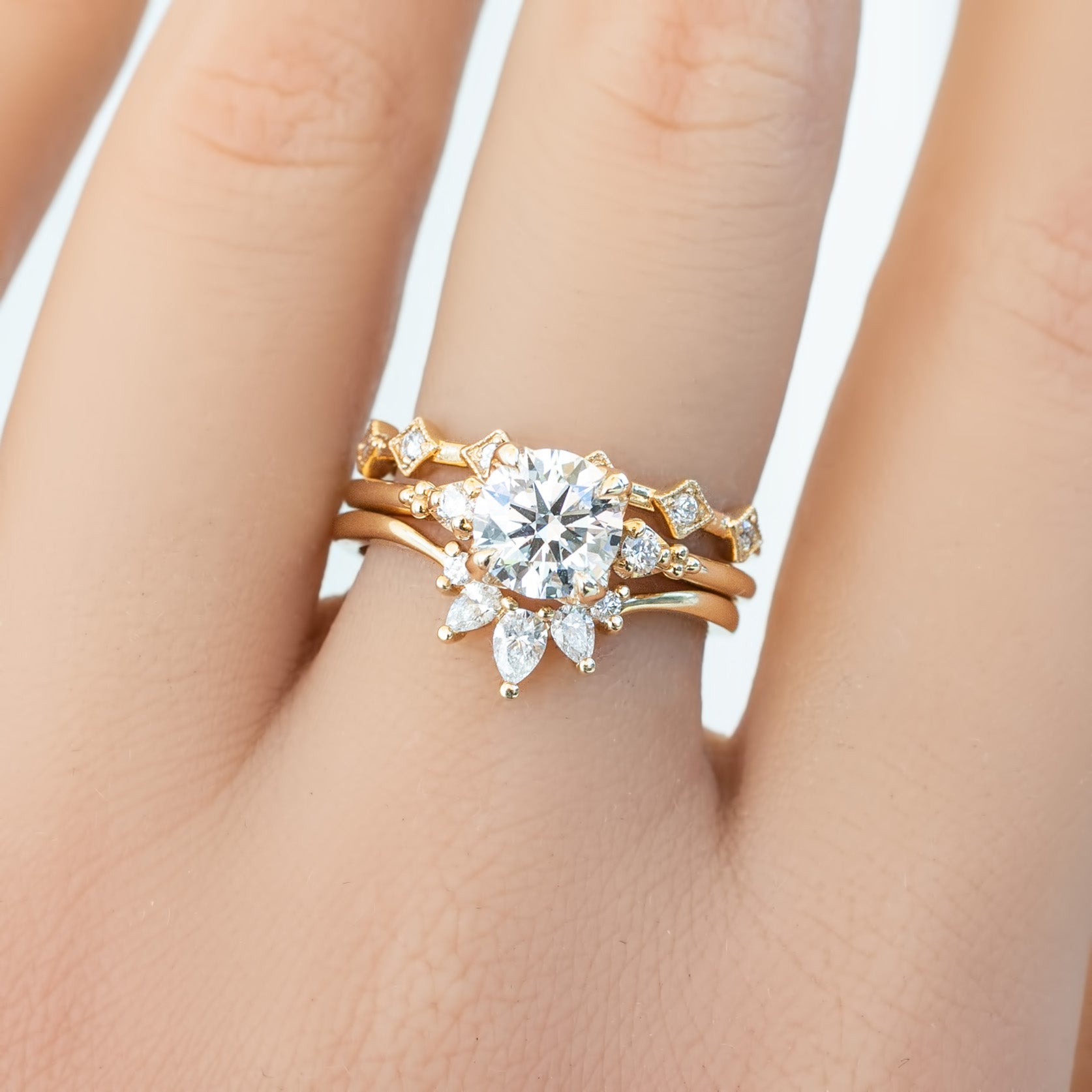 Close-up of a Six Star Ring featuring natural white diamonds set in ethically sourced solid gold on a finger