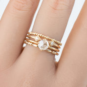 Close-up of a hand wearing a full eternity style bead Gemma Ring in ethically sourced solid gold with diamond accents.