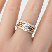 Hand wearing Eva Ring with natural white diamonds set in solid gold, featuring a sparkling centerpiece diamond