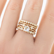 Gold Dahlia Diamond Eternity Ring with natural white bezel-set diamonds on a hand, showcasing full eternity design