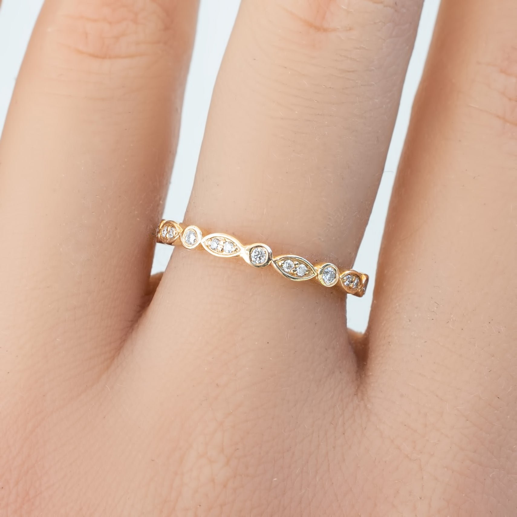 Delicate Seren Ring with natural white diamonds set in ethically sourced solid gold band on finger close-up