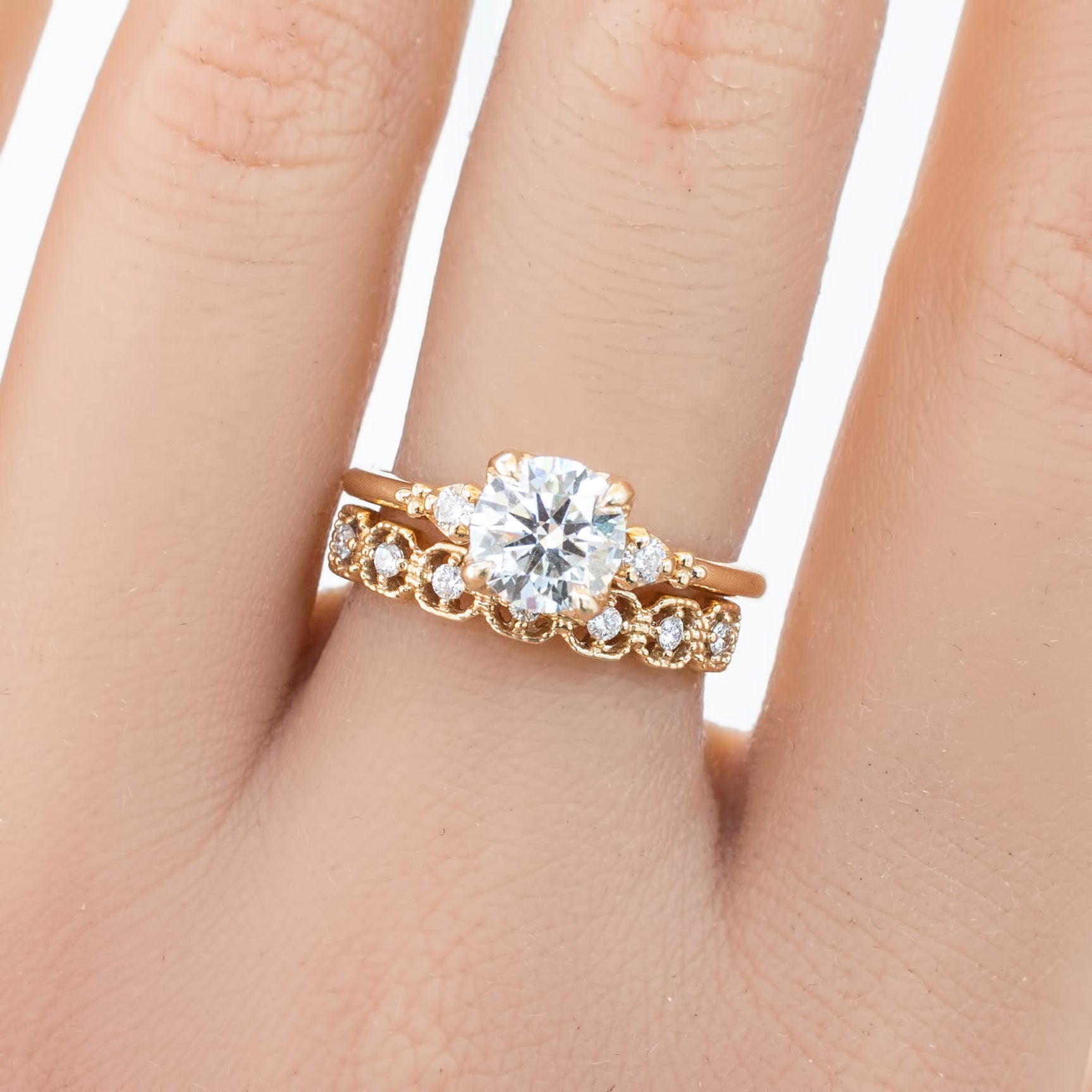 Hand wearing a milgrain square eternity ring with natural white diamonds set in solid gold band