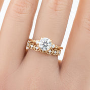 Hand wearing a milgrain square eternity ring with natural white diamonds set in solid gold band
