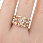 Hand wearing three ethically sourced solid gold rings with natural white diamonds and genuine gemstones