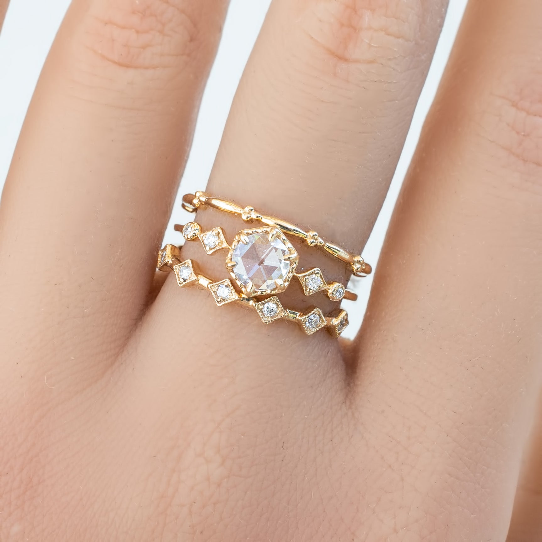 Gold Six Star Ring with natural white diamonds on finger in recyclable kraft box packaging