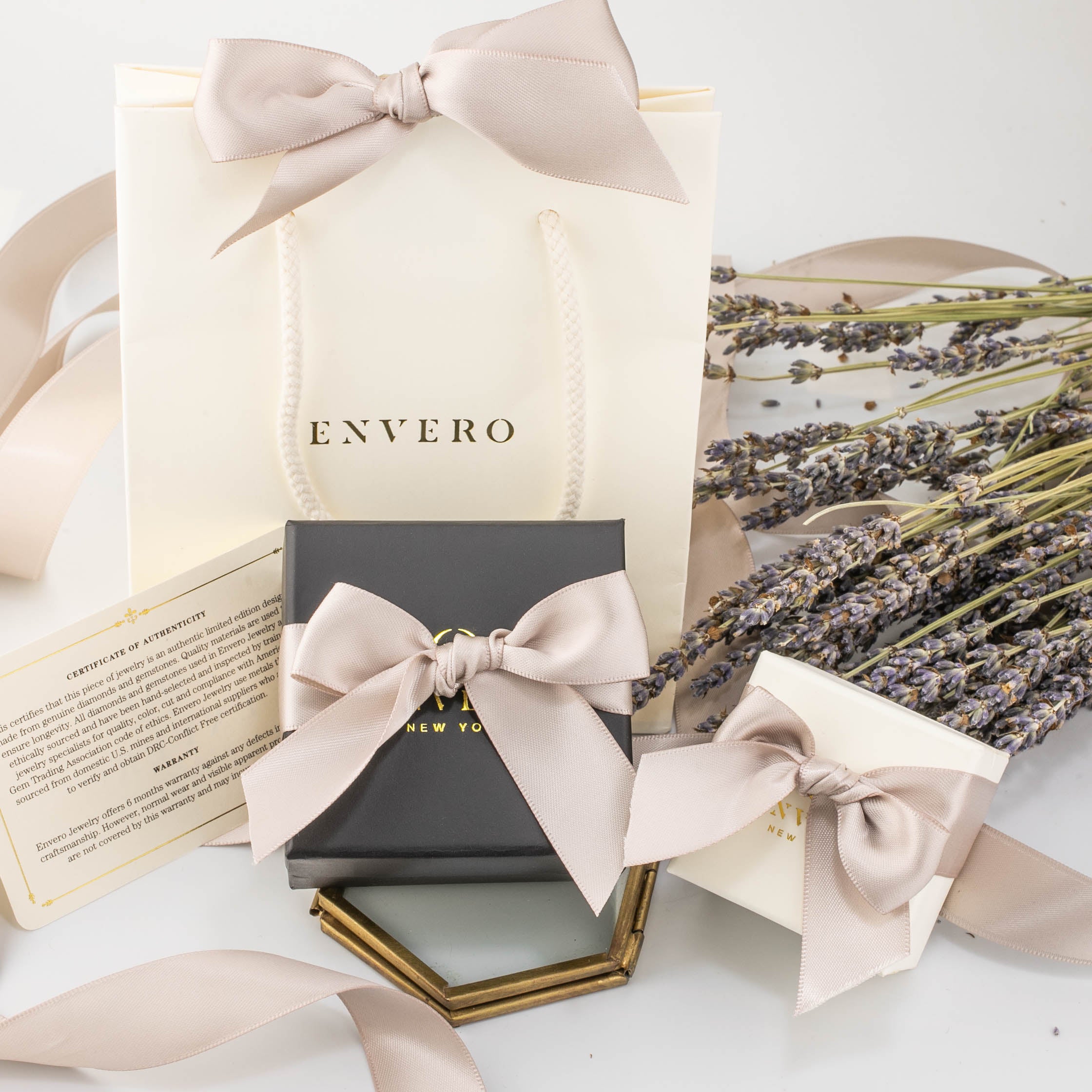 Elegant Envero gift wrapping set with cream paper bag, black and white boxes, blush ribbon, and dried lavender accents