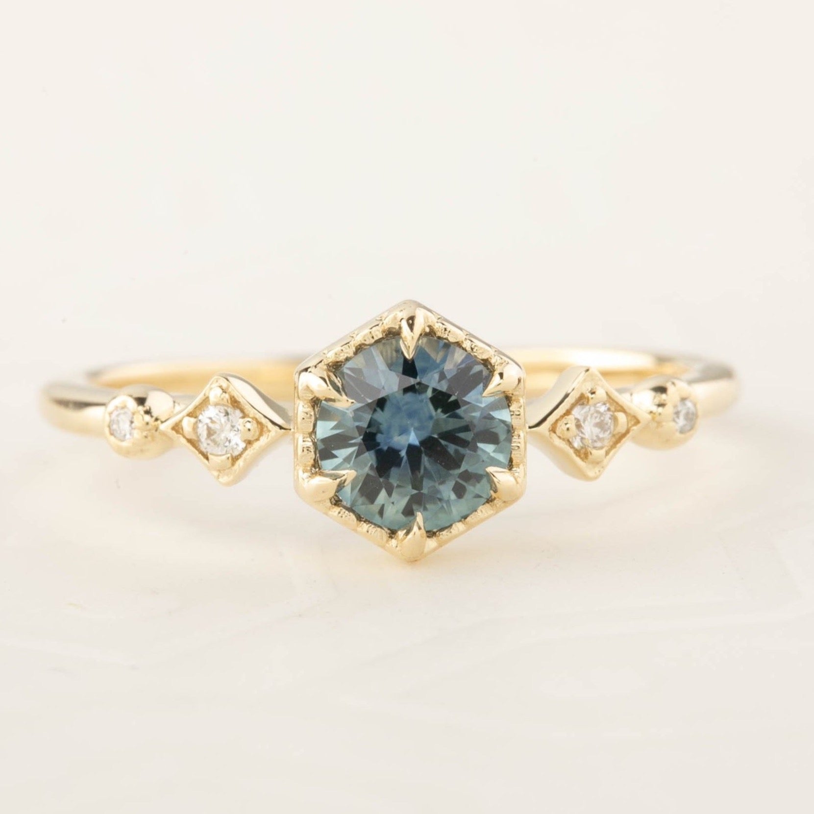 Stella Setting round cut ring with a blue center stone, handmade in recycled 14k gold with natural accent diamonds