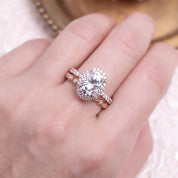 Hand wearing Neo Moissanite Halo Ring with 3ct center stone and rose gold half-eternity band sparkling in light.