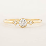 Gold moon and star ring with brilliant cut center diamond and two smaller accent diamonds in milgrain bezel setting