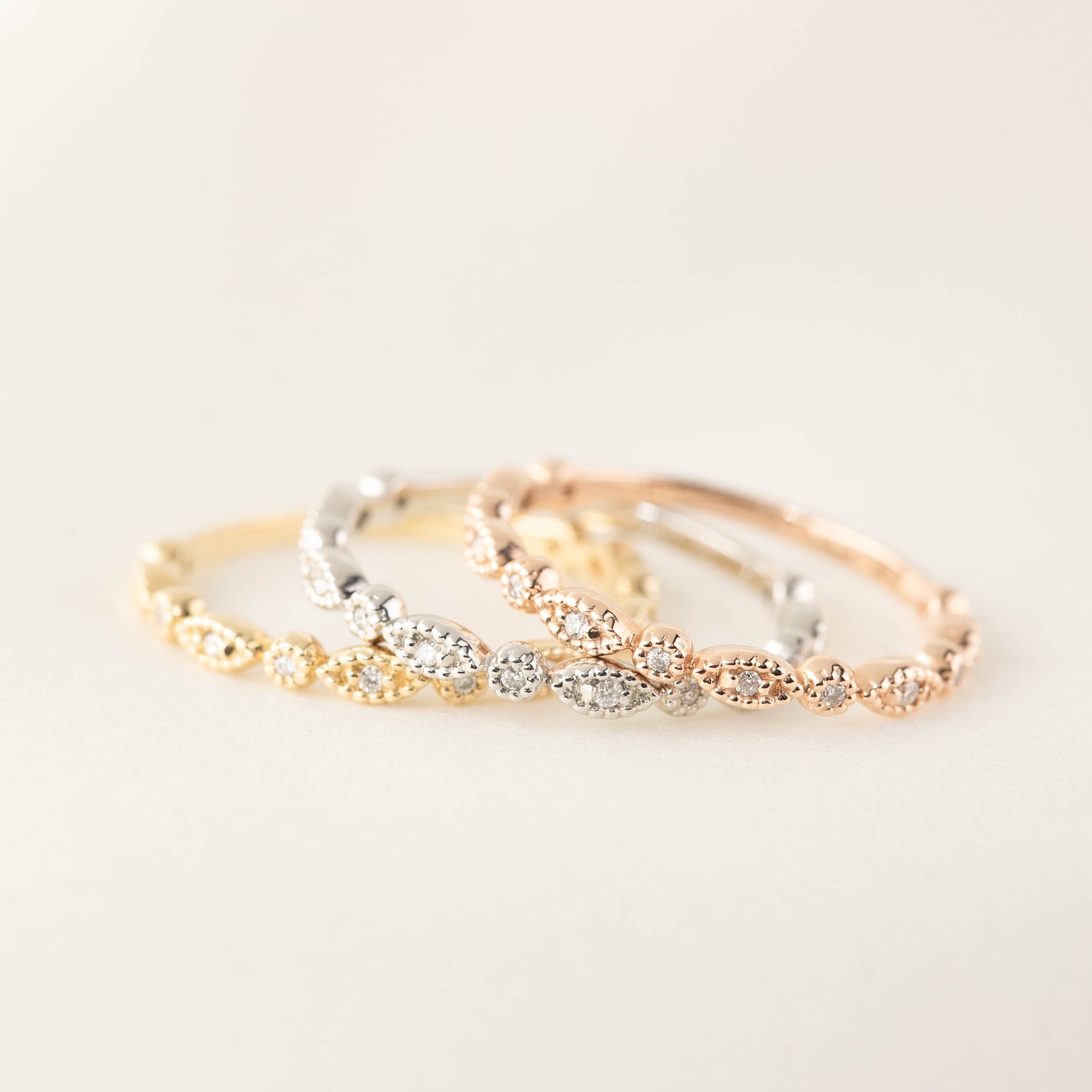 Set of three Tia Petite half and full eternity rings in yellow, white, and rose gold with milgrain detailing and diamonds