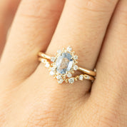 Close-up of Norah Tiara Ring with oval stone surrounded by natural white diamonds set in solid gold band