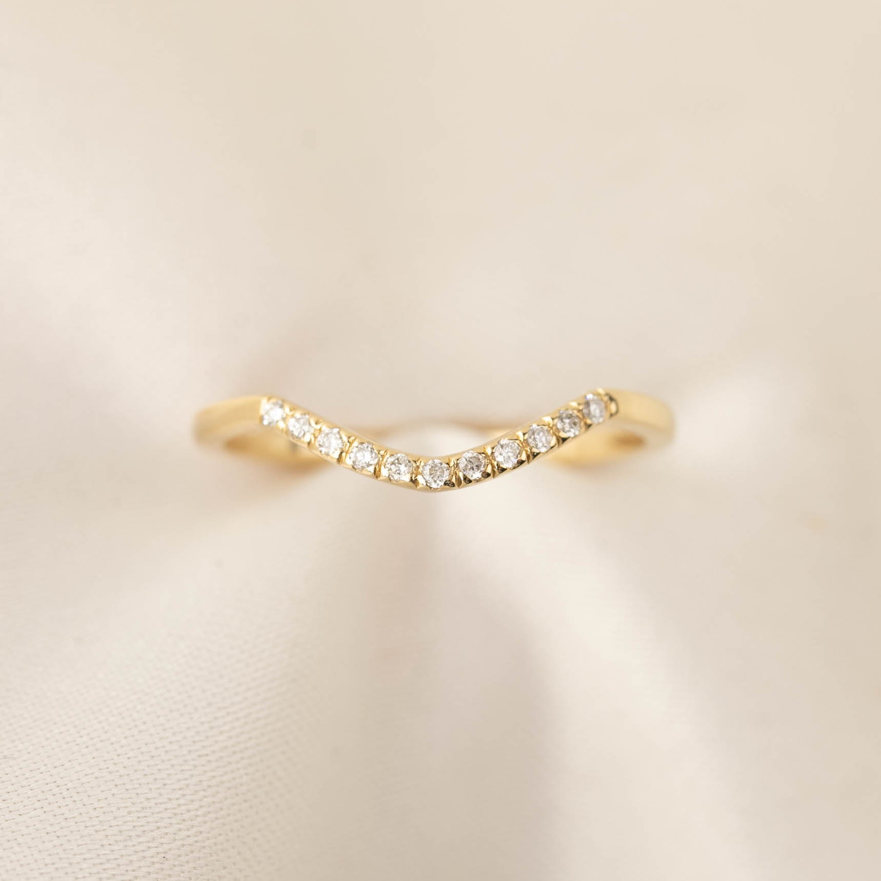 Delicate Esperanza Ring with natural white diamonds set in ethically sourced solid gold band on cream fabric background