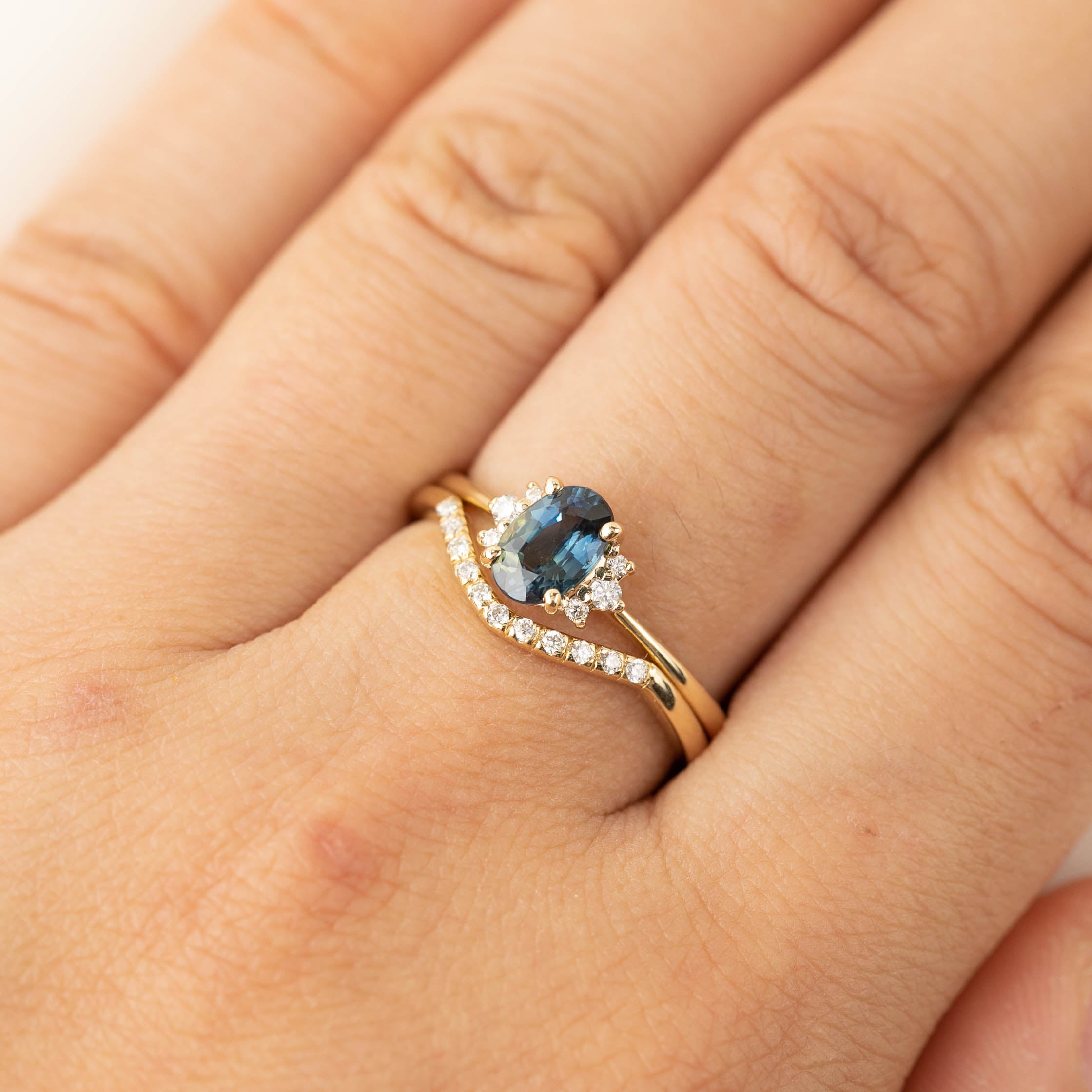 Esperanza Ring with natural white diamonds and a blue gemstone set in ethically sourced solid gold band on finger