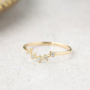 Delicate V-shaped solid gold star tiara ring with natural white diamonds, packaged in recyclable kraft jewelry box.