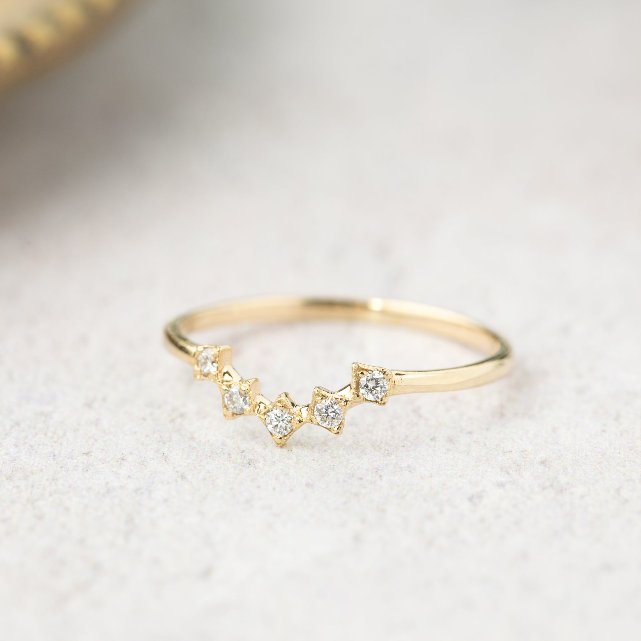 Delicate V-shaped solid gold star tiara ring with natural white diamonds, packaged in recyclable kraft jewelry box.