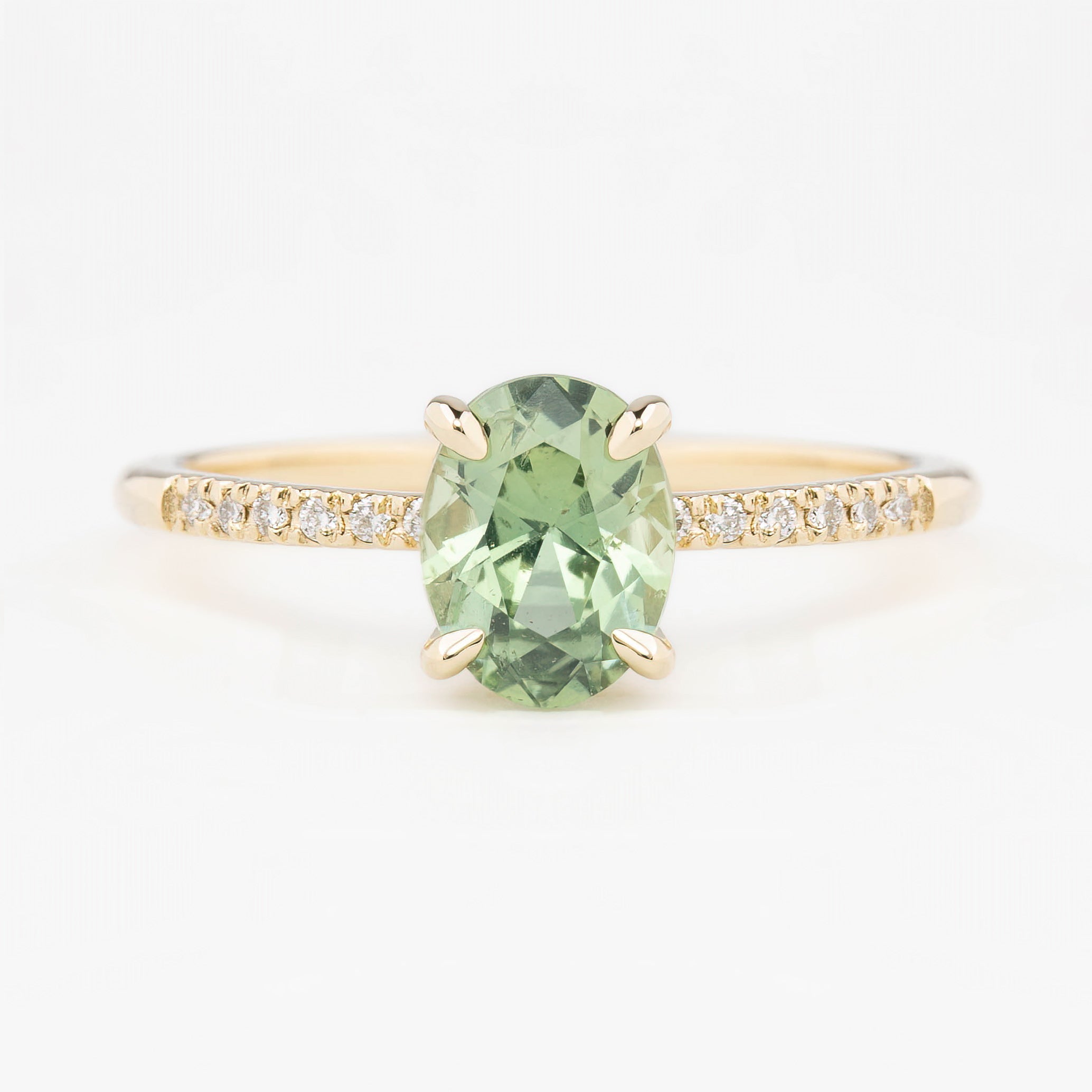 Audrey Setting(Oval cut) ring with green oval gemstone and small accent diamonds on a recycled 14k gold band