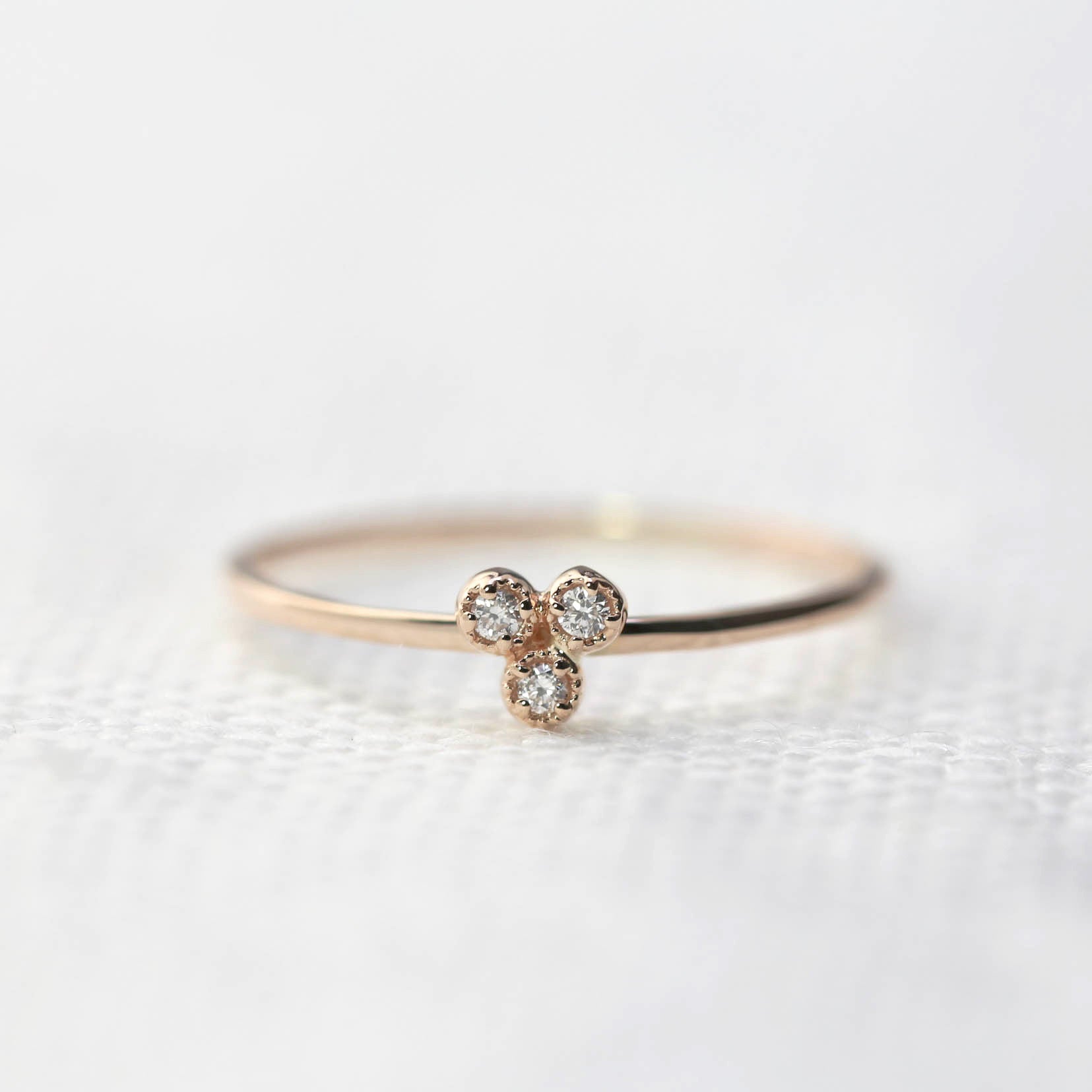 Dahlia Trio Diamond Ring with three bezel-set white diamonds on a thin recycled gold band for stacking.