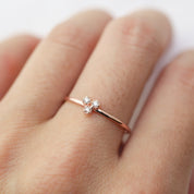 Dahlia Trio Diamond Ring with three brilliant white diamonds on a thin recycled gold band, worn on finger.