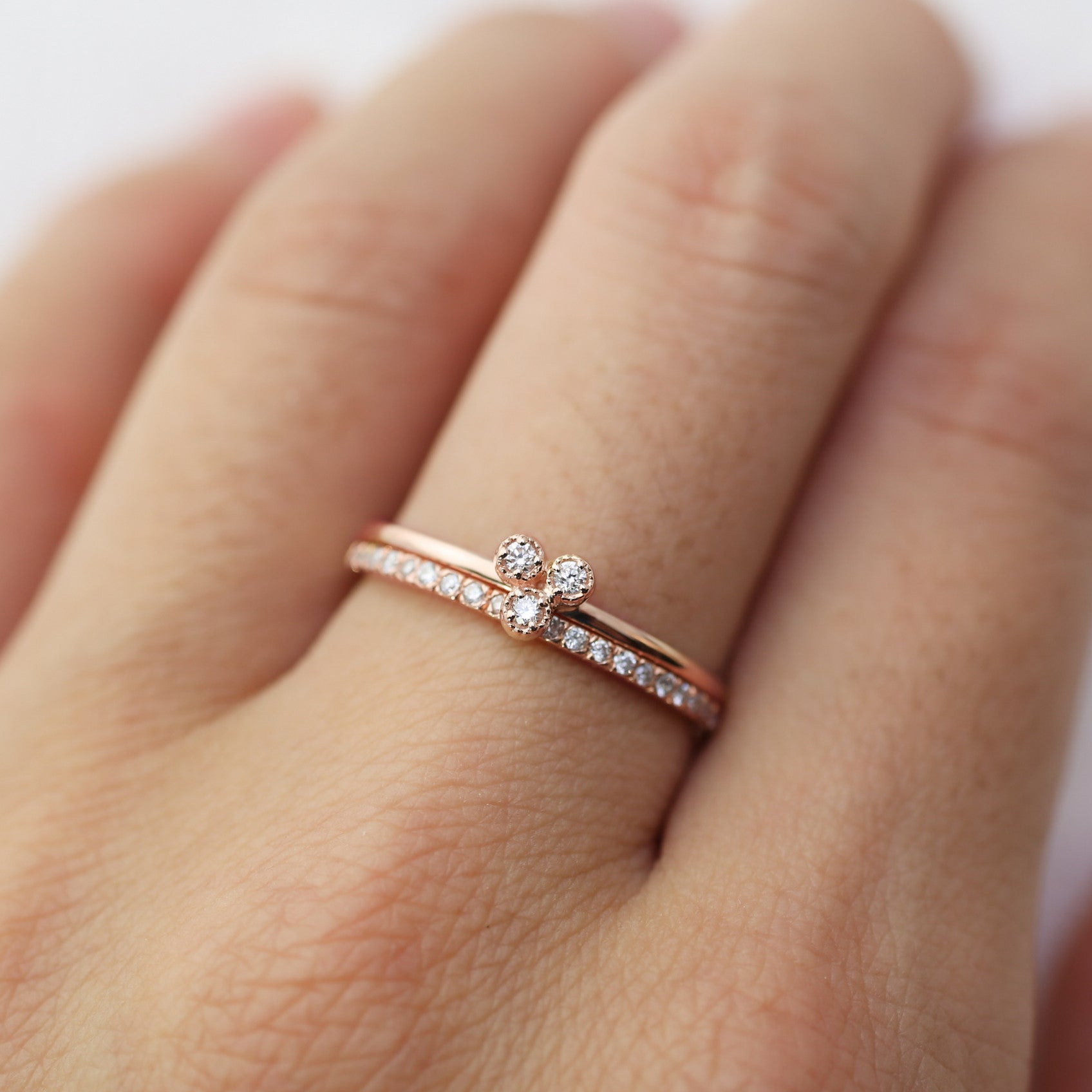 Dahlia Trio Diamond Ring with three brilliant cut diamonds and slim band on finger, made of recycled solid gold