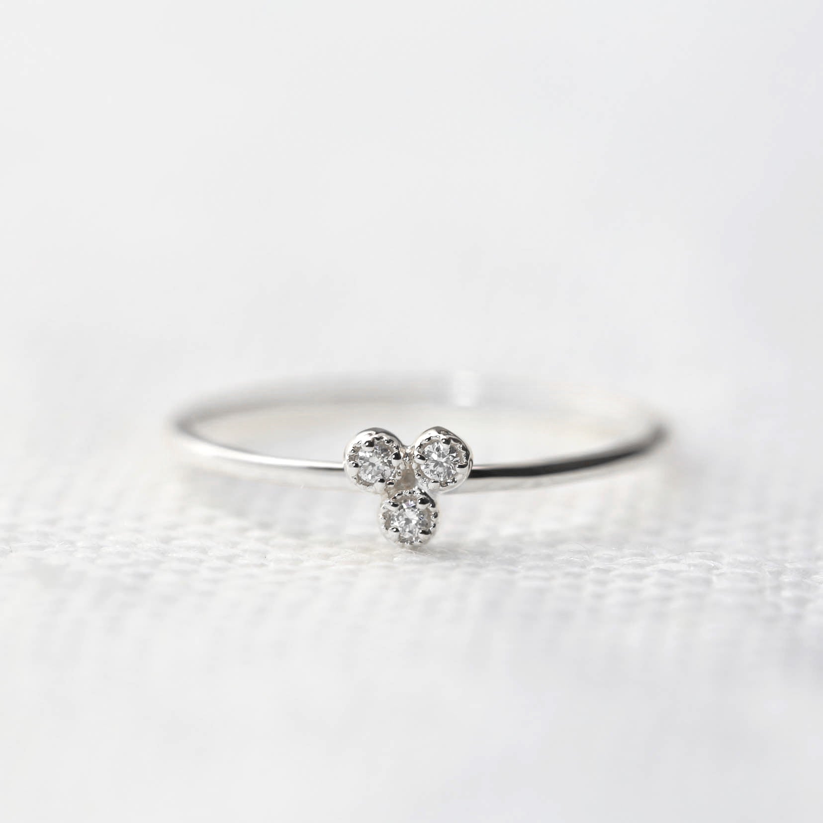 Dahlia Trio Diamond Ring with three brilliant cut white diamonds on a thin recycled solid gold band.
