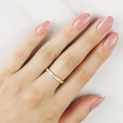 Hand wearing Eva ring with half-eternity natural white diamonds set in solid gold band, polished nails visible.