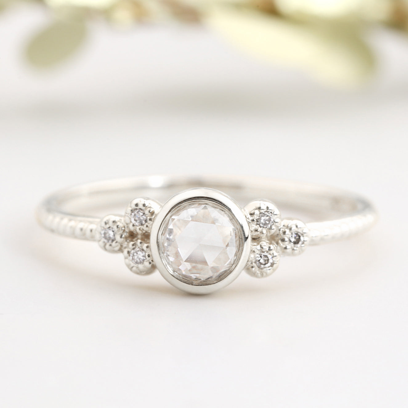 Close-up of Faye Ring featuring a 4mm rose cut diamond with six smaller diamonds on a delicate white gold band