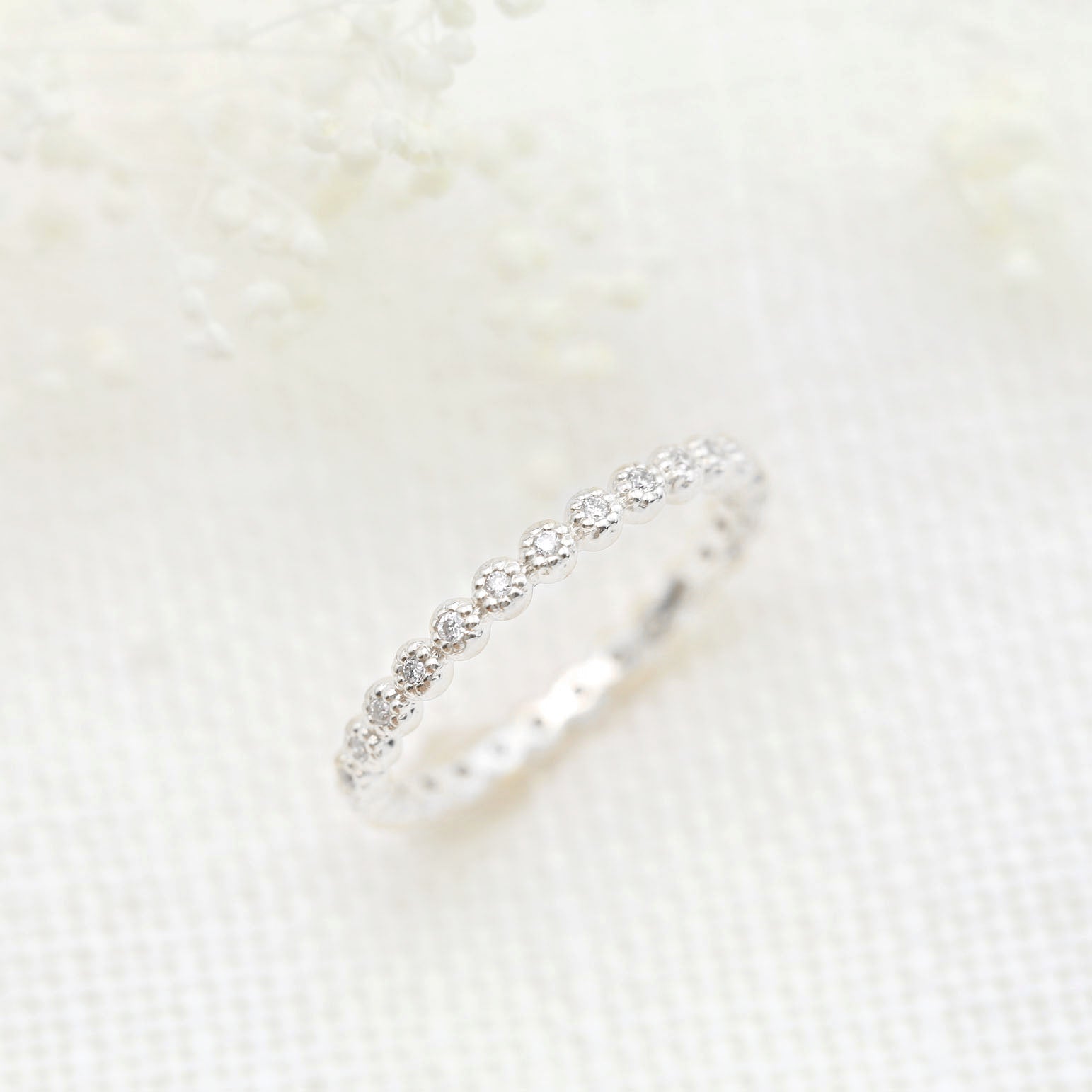 Dahlia Diamond Eternity Ring with natural white diamonds set in a delicate bezel setting on a slim band.