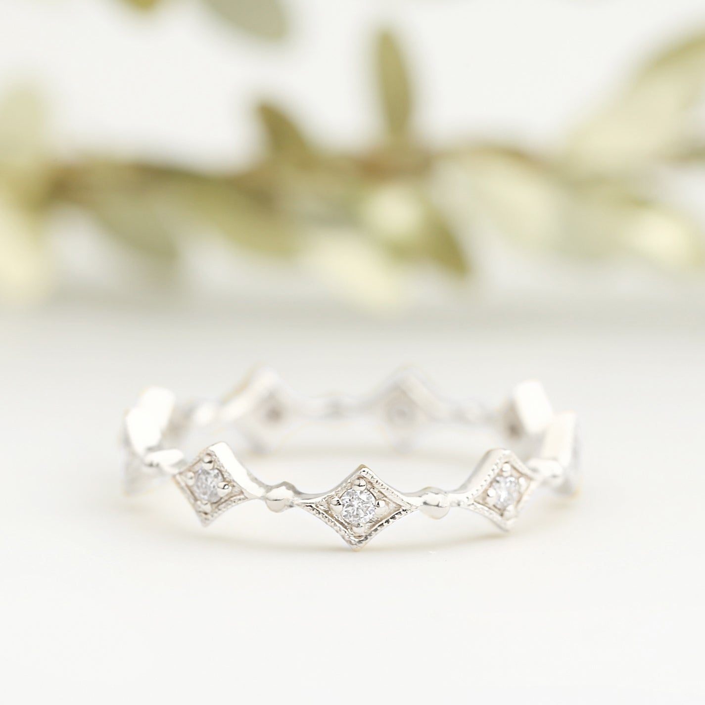 Close-up of a Star Diamond Eternity Ring with white diamonds set in ethically sourced solid gold band