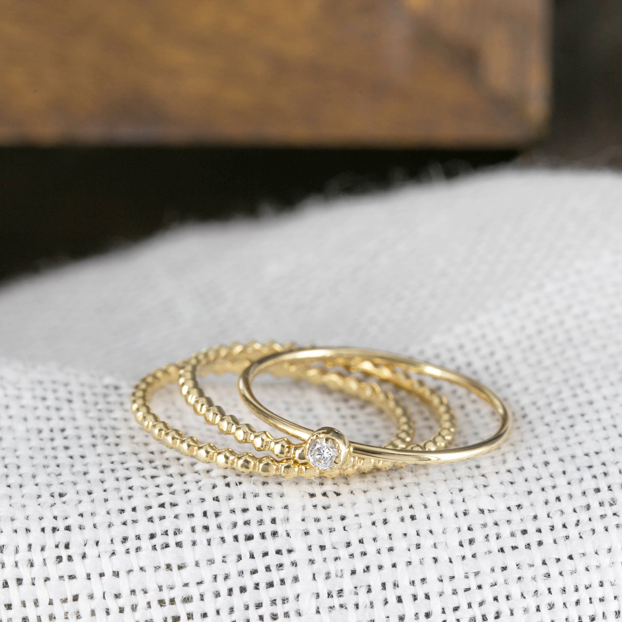 Set of delicate gold rings including a bead eternity ring and a thin gold band with a small diamond detail