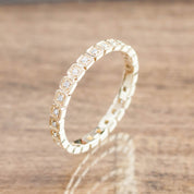 Hazel Eternity Ring with natural white diamonds set in ethically sourced solid gold on wooden surface background